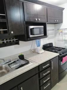 a kitchen with a microwave and a stove top oven at (2) cuarto maravilloso para descansar y asearse in Tlazcalancingo