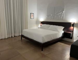 una camera da letto con un letto grande con lenzuola bianche di Domus Delia Luxury Apartment a Napoli