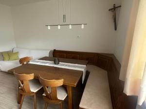 a dining room with a wooden table and chairs at Garni Schanz in Resia