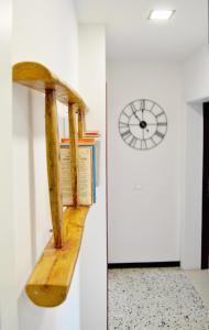 a wooden shelf next to a wall with a clock at Le Bassotte b&b in Perugia