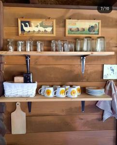 a wooden shelf with plates and dishes on it at Zakeliškių vandens malūno stovyklavietė in Zakeliškiai