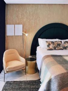 1 dormitorio con 1 cama, 1 silla y 1 lámpara en Dolce vita luxurious apartment, en Umhlanga