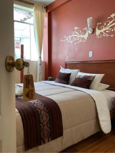 a bedroom with two beds and a red wall at Hotel Andean Host Inn in Cusco