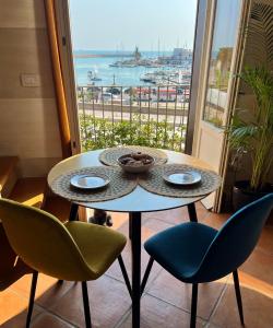 a table and chairs with a view of a harbor at Una finestra sul mare in Bari