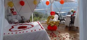 a room with a bed with a heart made out of balloons at Glamping Campestre Uriyahu in Macanal