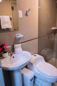 a bathroom with a white toilet and a sink at Hostal Samakuy AQP in Arequipa