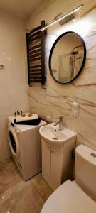 W łazience znajduje się toaleta, umywalka i lustro. w obiekcie Apartament Sosnowiec - Kazimierz Górniczy w mieście Sosnowiec