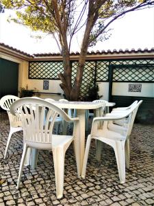 una mesa blanca y sillas en un patio en Vivienda en la playa de los surfistas! Baleal-Portugal - Hasta 11 PAX, en Ferrel