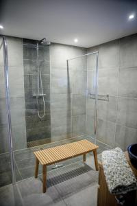 y baño con ducha y banco de madera. en Le gîte du Bois de Loo, en Attert