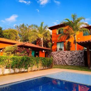 a house with a swimming pool in front of a house at BemTeVi Em Búzios in Búzios