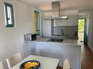 a kitchen with a table with a bowl of flowers on it at Villa Jacqueline in La Seyne-sur-Mer +10 photos