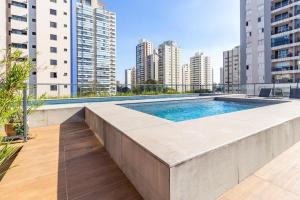 a swimming pool on top of a building with tall buildings at Lindo apt na pompéia! in Sao Paulo