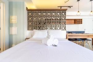 Un dormitorio con una cama blanca con toallas. en Lindo apt na pompéia!, en São Paulo