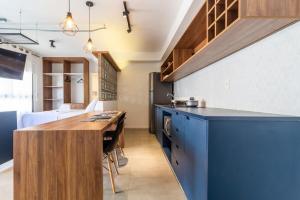 uma cozinha com um balcão azul e uma mesa em Lindo apt na pompéia! em São Paulo