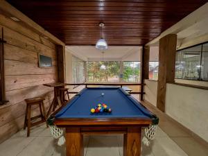 una mesa de billar en una habitación con paredes de madera en Pousada do Albatroz, en Cabo Frío