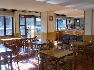 a restaurant with tables and chairs and a bar at Hotel Arnal in Escalona