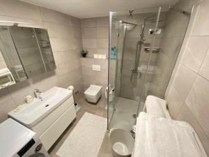 a bathroom with a shower and a sink and a toilet at Apartments Flora 1 in Rab +24 photos