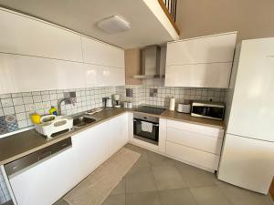a kitchen with white cabinets and a white refrigerator at Apartments Flora 1 in Rab