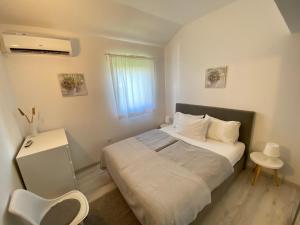 a small bedroom with a bed and a window at Apartments Flora 1 in Rab