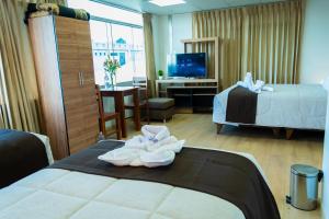 Habitación de hotel con 2 camas y TV en Hostal Samakuy AQP en Arequipa