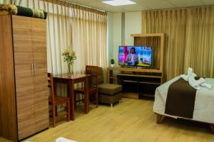 Habitación de hotel con 1 dormitorio con TV y 1 cama en Hostal Samakuy AQP, en Arequipa