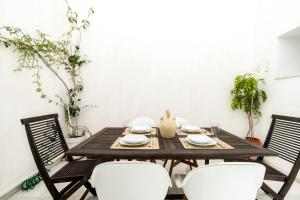 comedor con mesa de madera y sillas en El Erizo Apartamentos, en Tarifa