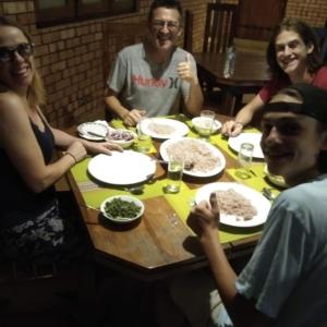 a group of people sitting around a table eating food at Komaligma villa by camrin Group 