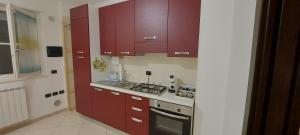 a kitchen with red cabinets and a stove at Casa vacanze Fantasia - Nuovo! Accogliente appartamento in Barletta