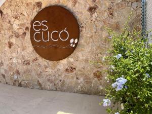 a sign on the side of a stone wall at Es Cucó in Cala Galdana