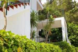 a white building with a staircase and plants at Es Cucó in Cala Galdana