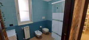 a blue bathroom with a toilet and a sink at Casa vacanze Fantasia - Nuovo! Accogliente appartamento in Barletta +18 photos