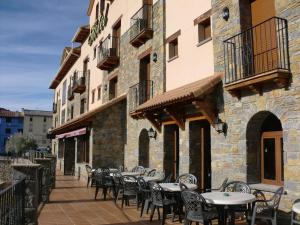 un patio avec des tables et des chaises dans un bâtiment dans l'établissement Hotel Arnal, à Escalona