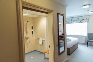 a bathroom with a shower and a bedroom at The Woburn in Woburn