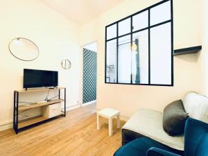 - un salon avec un canapé et une grande fenêtre dans l'établissement Lodge Cassard, à Nantes