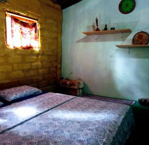 a bedroom with a bed in a room with a window at Chalé Chapada dos Veadeiros in Cavalcante