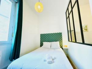 een slaapkamer met een bed met twee handdoeken erop bij Lodge Cassard in Nantes