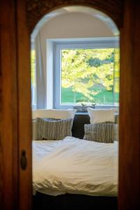 2 camas en una habitación con ventana en Le gîte du Bois de Loo, en Attert