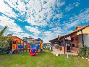 un patio trasero con un parque infantil con un tobogán en Pousada do Albatroz, en Cabo Frío