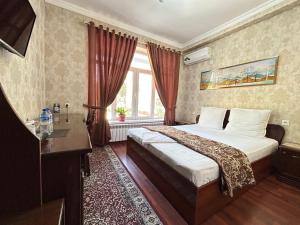 a hotel room with a bed and a window at Hotel Ishonch in Samarkand