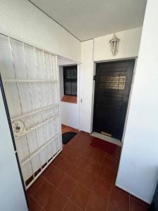 pasillo con puerta negra y suelo de baldosa en Casa Da Maria, en Albufeira