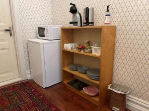a kitchen with a microwave and a small refrigerator at Rum på Gårdstånga Prästgård in Flyinge