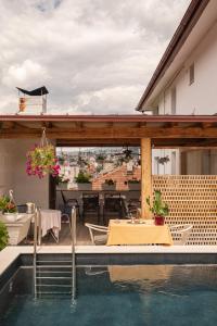 a patio with a table and a swimming pool at Guesthouse Rose in Sarajevo