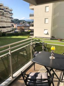 balcone con tavolo e sedie. di Lugano Ferienwohnung nähe vom See mit Swimmingpool & Sauna a Paradiso
