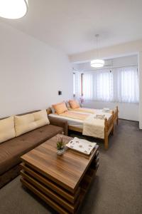 ein Wohnzimmer mit einem Sofa und einem Tisch in der Unterkunft Guesthouse Rose in Sarajevo