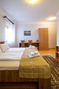 a bedroom with a large bed with towels on it at Guesthouse Rose in Sarajevo