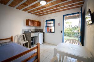 Habitación con cama, mesa y cocina. en Pousada Natureza, en Florianópolis