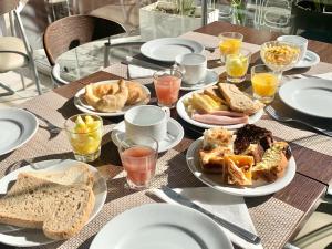 una mesa con platos de comida y pan. en Sarum Hotel Design en Buenos Aires