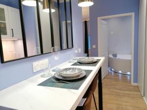 a kitchen with a table with plates and wine glasses at Suite Bubbles Spa - Luxe - Centre Ville - calme - wifi in Troyes