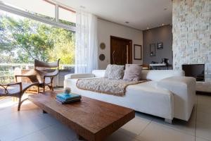 ein Wohnzimmer mit einem weißen Sofa und einem Tisch in der Unterkunft Casa com Jacuzzi Vista Mar no Campeche P2299 in Florianópolis