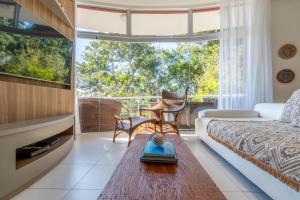 uma sala de estar com um sofá e uma grande janela em Casa com Jacuzzi Vista Mar no Campeche P2299 em Florianópolis
